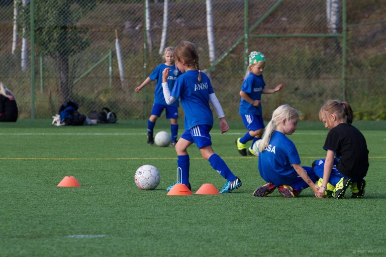 Lapsi kuljettaa jalkapalloa